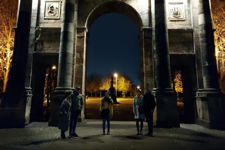 a group of people standing in front of a building at night