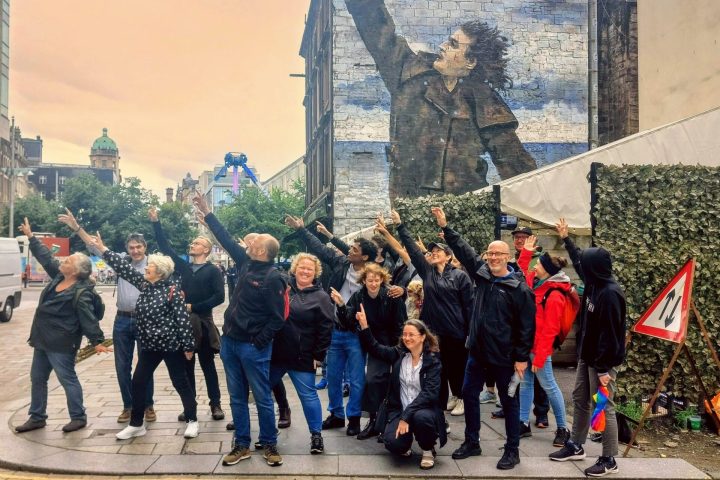 a group of people standing in front of a brick building