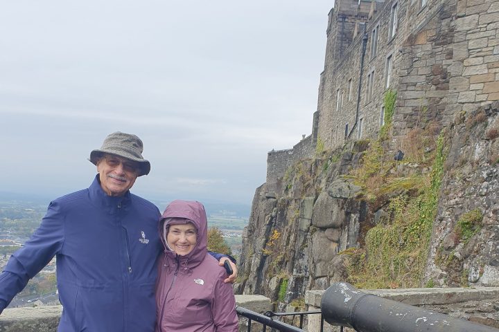 a man and a woman standing next to a fence