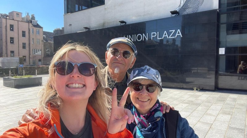 a person wearing sunglasses and standing in front of a building