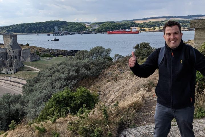 a man standing next to a body of water