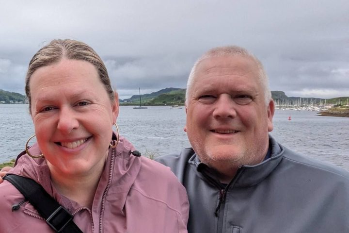a couple of people standing in a body of water posing for the camera
