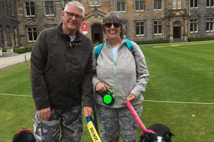 a person holding a dog on a leash in front of a building