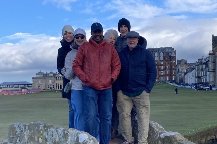 a man and a woman standing in front of a large rock