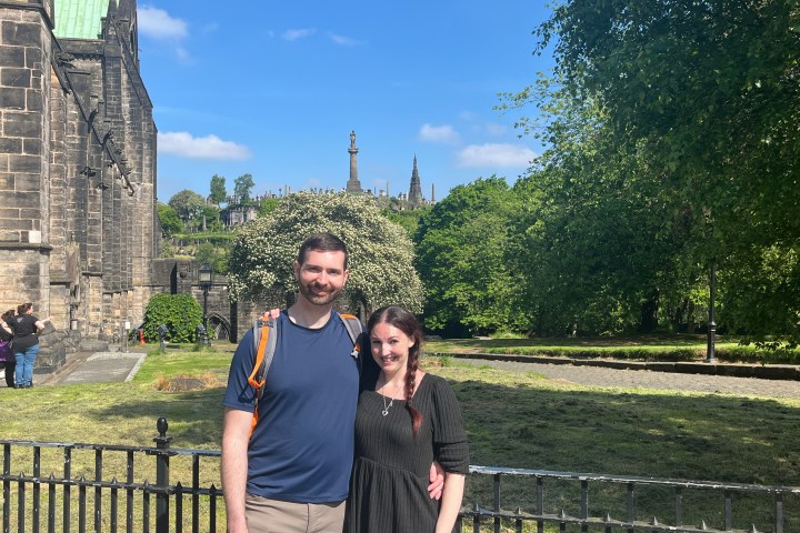 a man standing in front of a fence