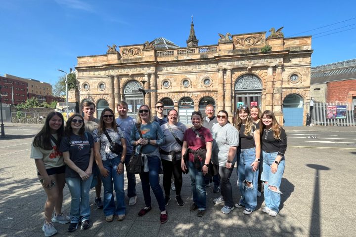 a group of people posing in front of a building