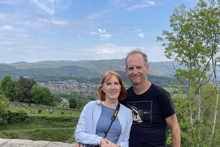 a man standing on top of a grass covered field