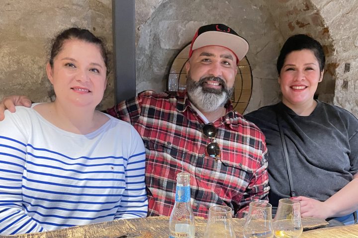 a group of people sitting at a table with a cake