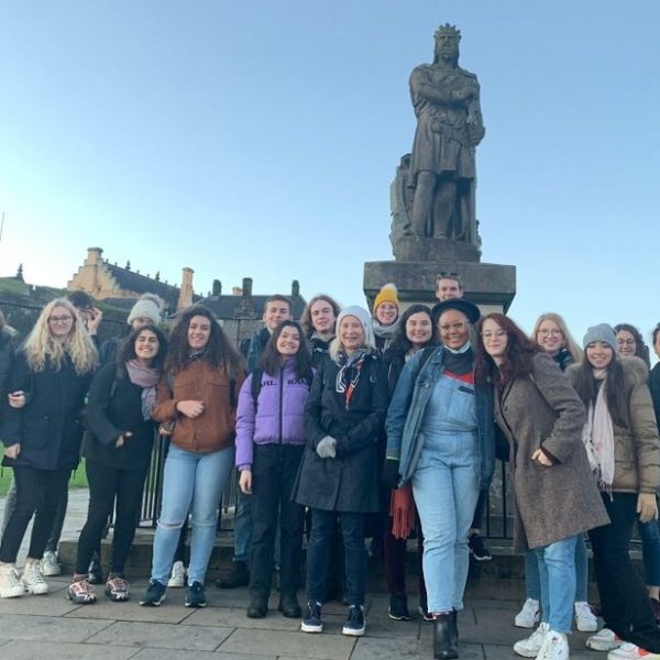 a group of people standing in front of a crowd posing for the camera