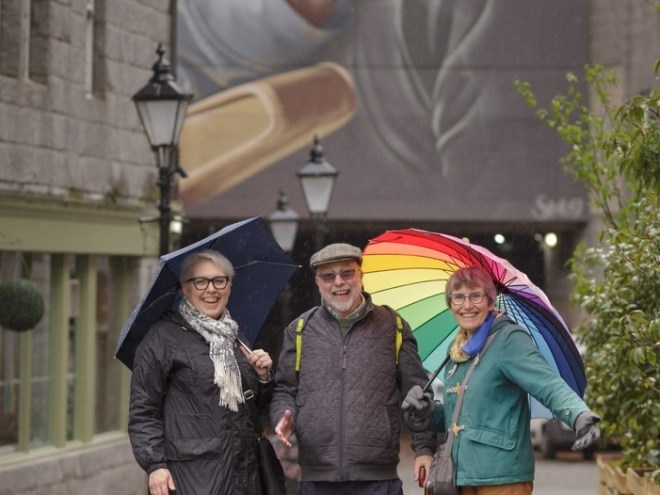 a man and a woman walking down a street holding an umbrella