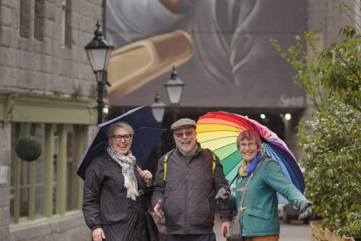 a man and a woman walking down a street holding an umbrella