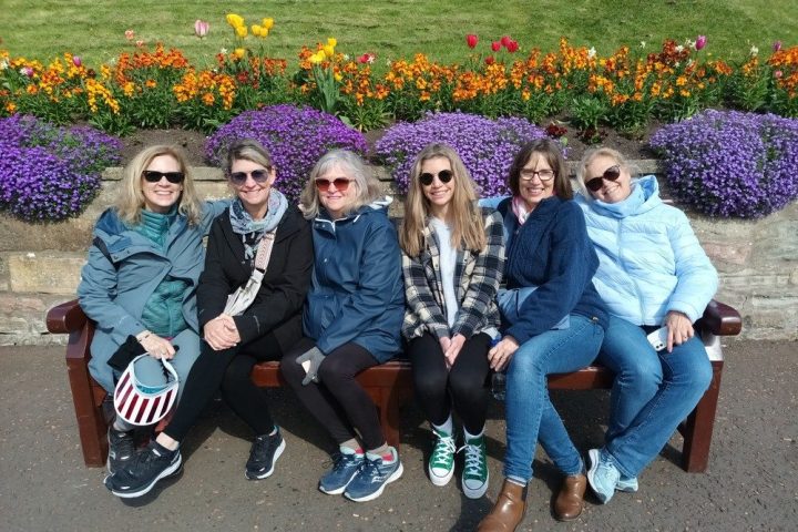 a group of people sitting on a bench posing for the camera