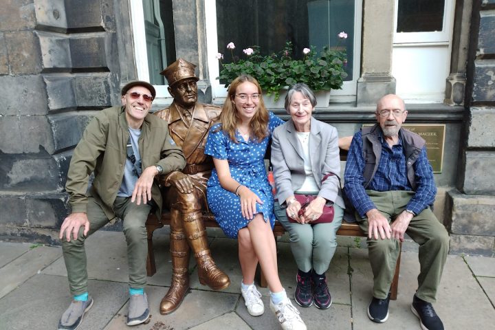 a group of people sitting on a bench posing for the camera
