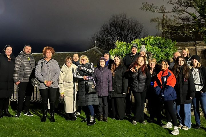 a group of people standing in front of a crowd posing for the camera