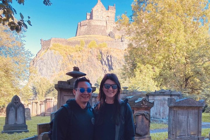a man and a woman standing in front of a tree