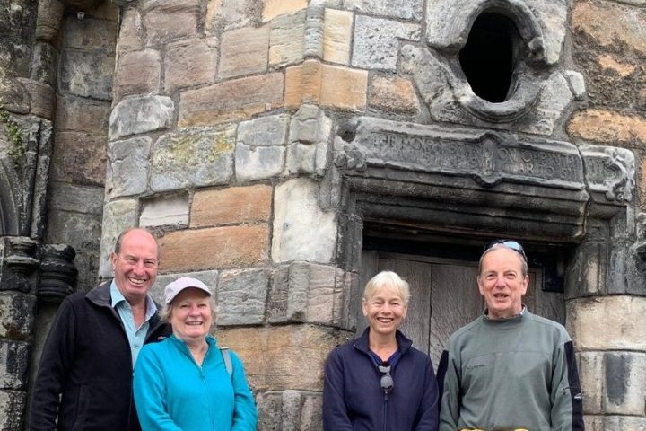 a man standing in front of a stone building