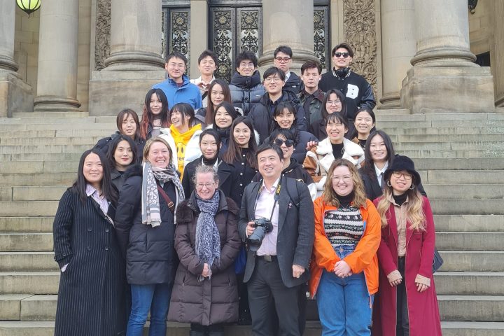 Christine Lewicki et al. posing in front of a building