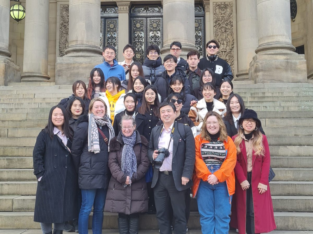 Christine Lewicki et al. posing in front of a building