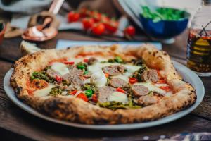 a pizza sitting on top of a plate of food on a table