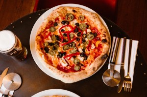 a pizza sitting on top of a wooden table
