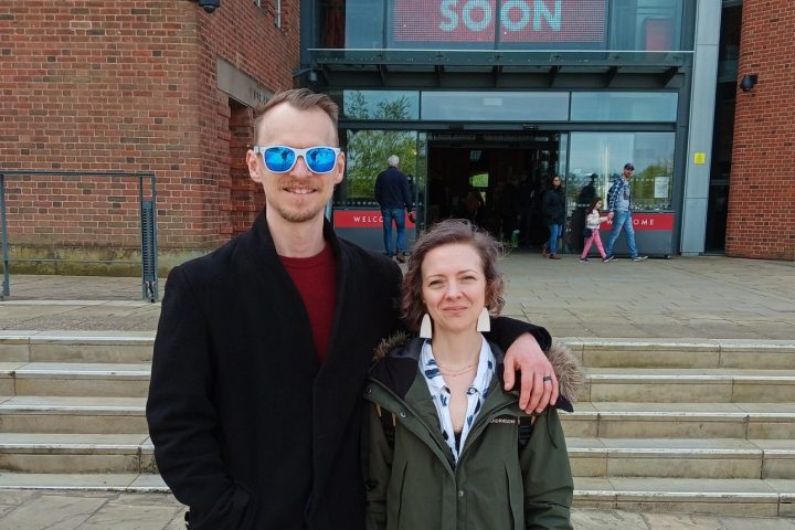a person standing in front of a brick building