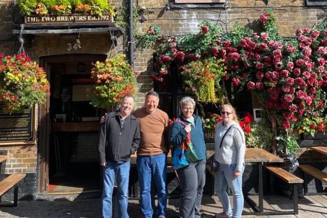 a group of people standing in front of a brick building
