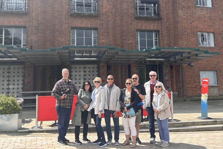 a group of people standing in front of a brick building