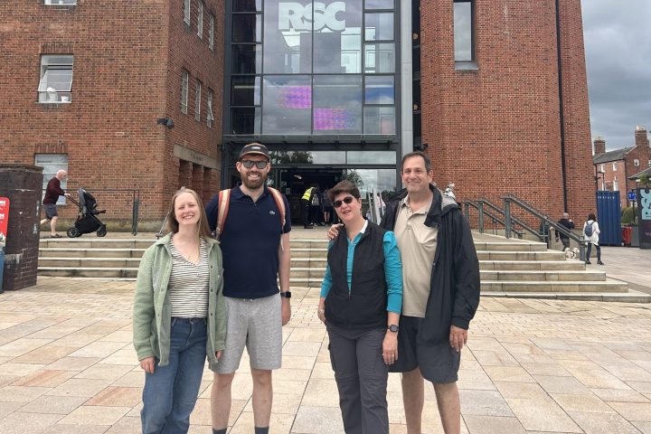 a group of people standing in front of a brick building