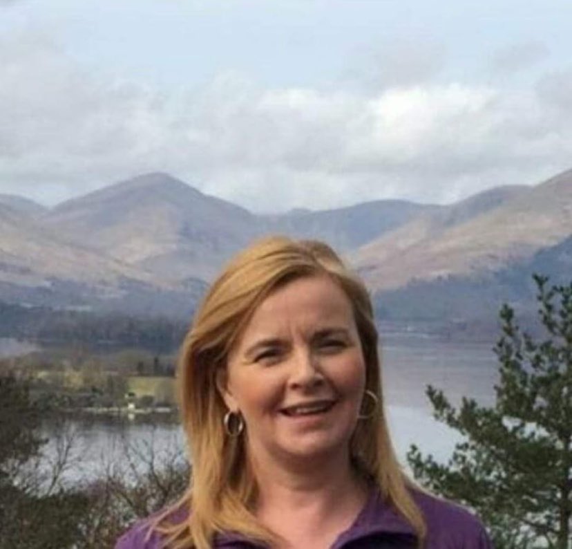 a woman standing in front of a mountain