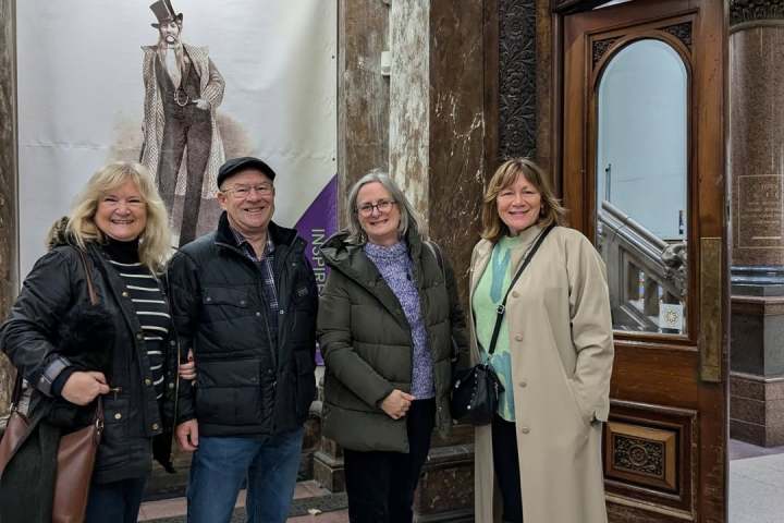 Susan Olsen et al. standing in front of a building