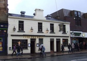 a group of people walking down a street in front of Karl Marx House