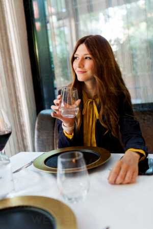 a woman sitting at a table in front of a window