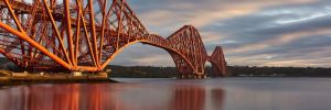 a train crossing Forth Bridge over a body of water