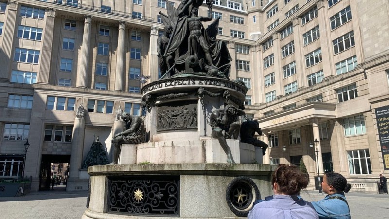 a statue of a person standing in front of a building
