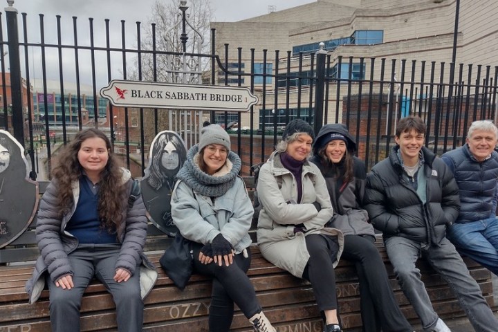 a group of people sitting on a bench posing for the camera