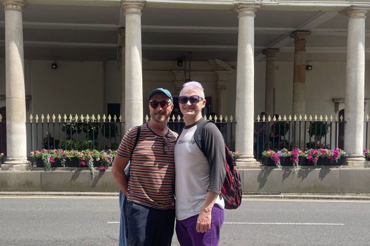 a person standing in front of a building talking on a cell phone