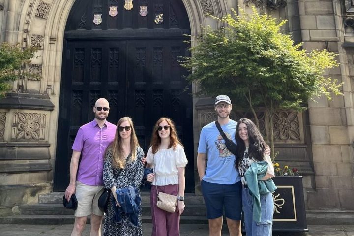 a group of people standing in front of a clock tower