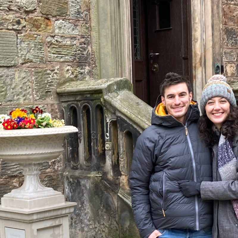 a woman standing in front of a brick building