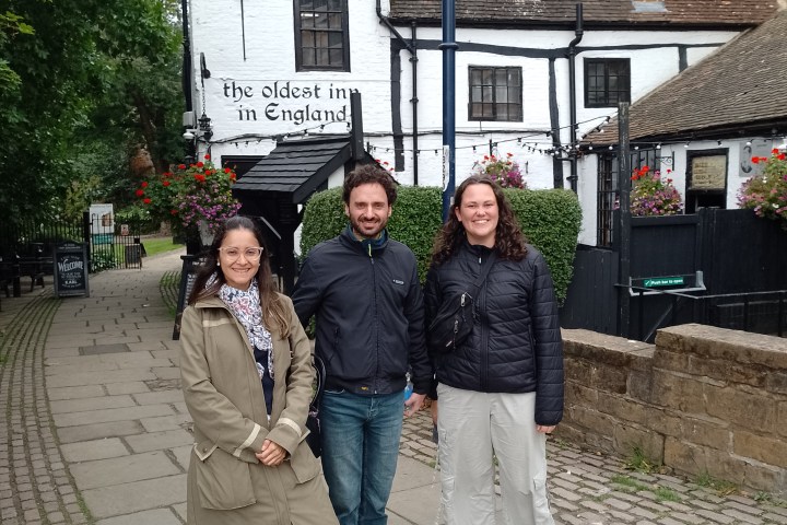 Three people standing in front of Ye Olde Trip to Jerusalem, a historic inn in England.