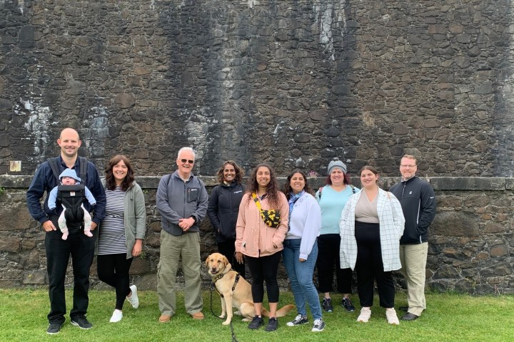 a group of people standing in front of a brick building