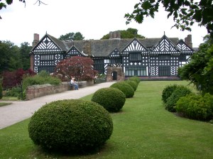 a large lawn in front of a house with Bramall Hall in the background