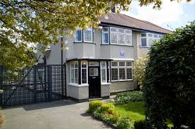 a small house in a tree with 251 Menlove Avenue in the background