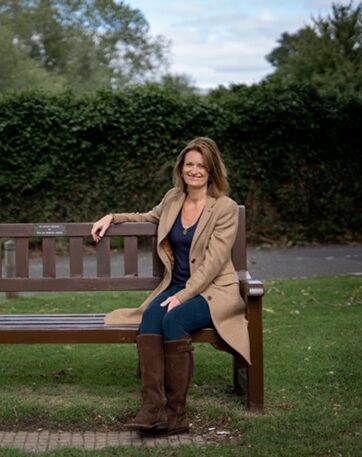 a person sitting on a bench in a park