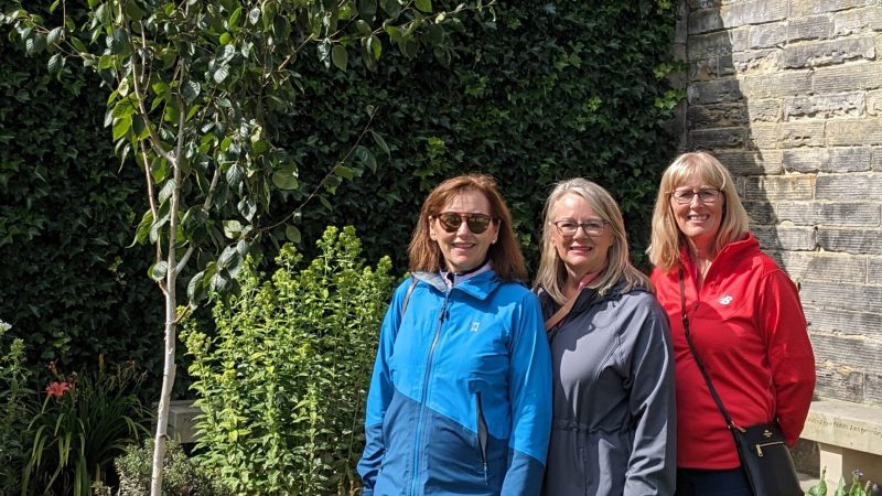 a group of people standing in front of a brick building
