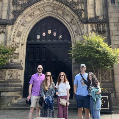 a group of people standing in front of a clock tower
