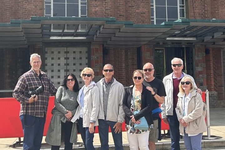 a group of people standing in front of a brick building