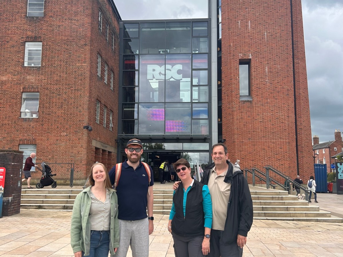a group of people standing in front of a brick building