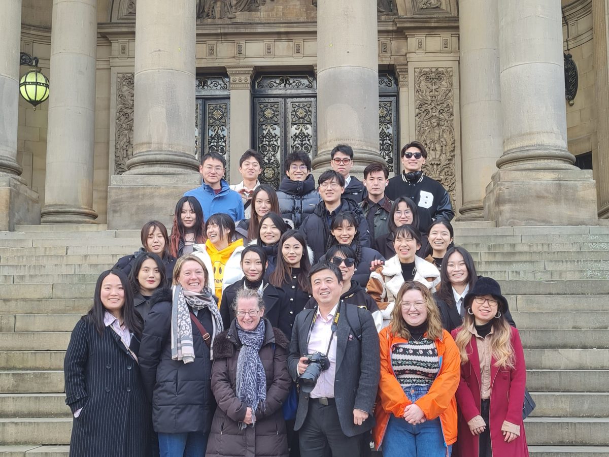 Christine Lewicki et al. posing in front of a building