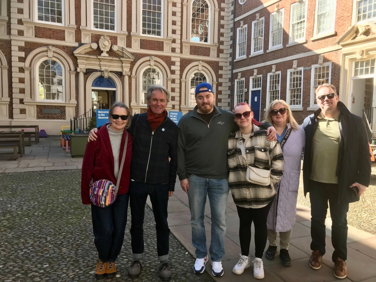 a group of people posing for a photo in front of a building