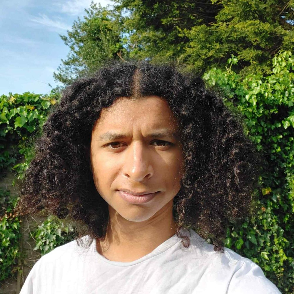 a person standing in front of a tree posing for the camera